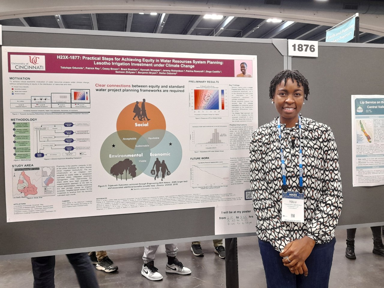 Tolulope Odunola stands in front of poster