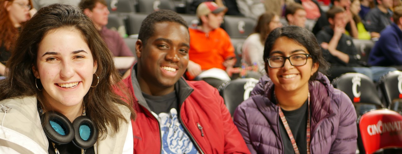 Three students at Fifth Third Arena, one student holding a robot