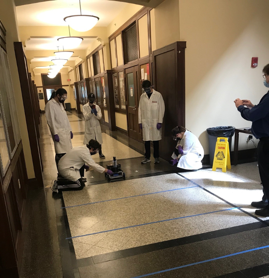 students in the hallway with car