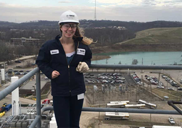 Emma Lowe, chemical engineering class of 2019, on her co-op assignment at BASF, wearing a hardhat and safety glasses with the plant in the background.
