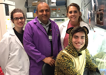 Erick Madis, biomedical engineering class of 2019, is pictured here wearing a halloween costume while working in a lab with fellow researchers.