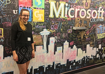 Tessa Wiedmann, computer science class of 2019, pictured in front of a creative Microsoft sign on a chalkboard.