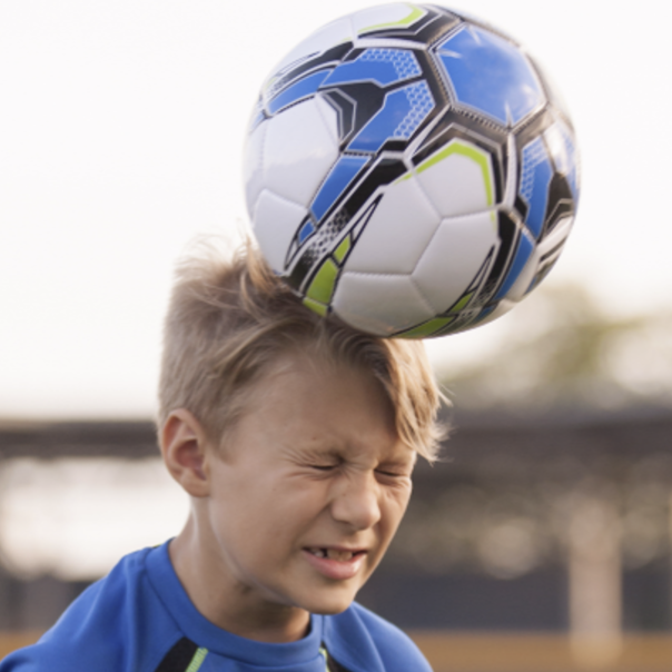 Kid hitting a soccer ball with his head